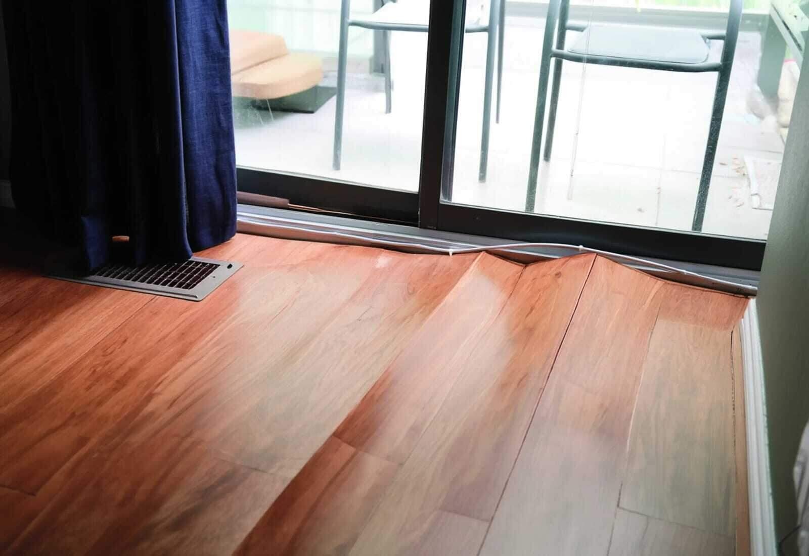 Cupped hardwood floor with raised board edges after a water leak in a Houston home